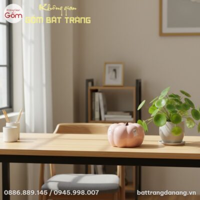 Heo đất bí ngô hồng đặt trên bàn làm việc gỗ sá...