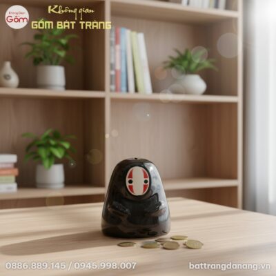 Ống tiết kiệm Vô Diện Bát Tràng đặt trên bàn là...