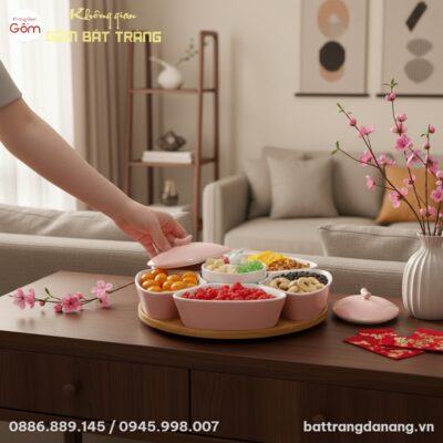 Bàn tay thanh lịch đặt khay mứt sứ hồng phấn lê...